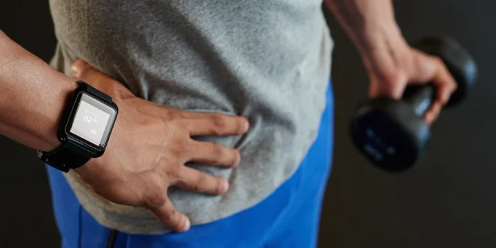 A man wearing the best fitness tracker while weightlifting