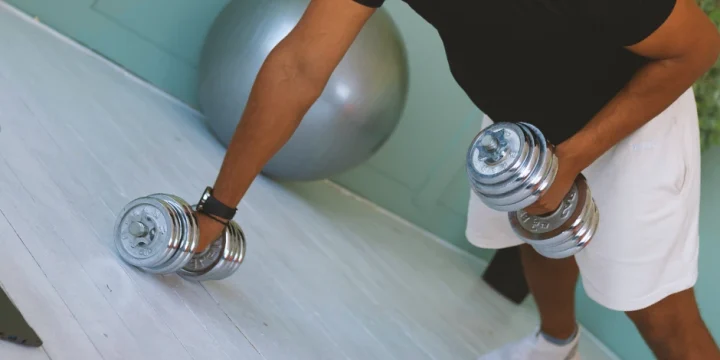 A person working out with free weights at home