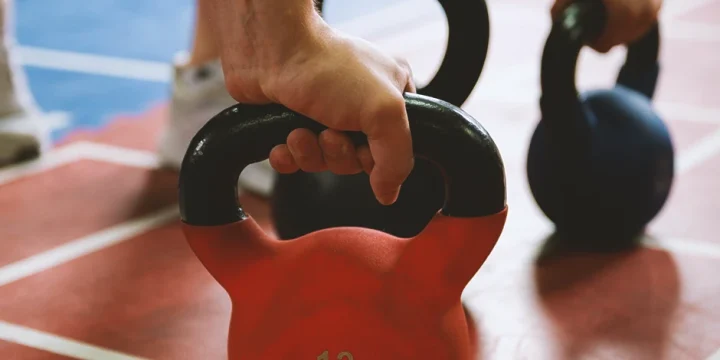 A person doing chest exercises with kettlebells at the gym