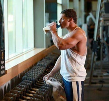Guy drinking weight gainer in the gym