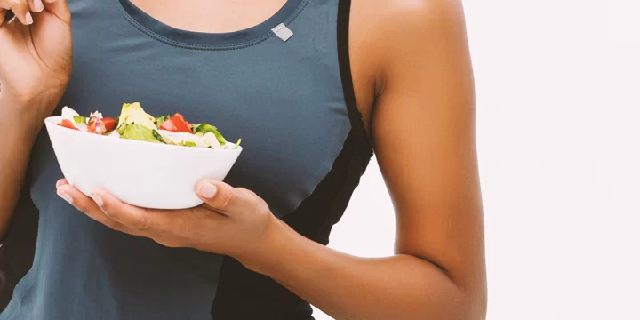 A fit person holding a bowl of food