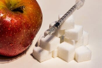 Sugar, injection and apple on a table