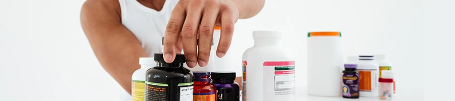 A close up shot of a man choosing a supplement to take