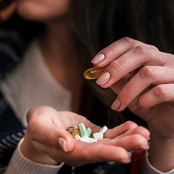 Woman choosing a variety of supplement pills
